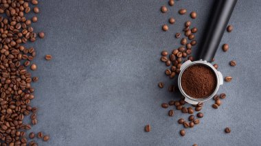 Üzerinde kahve ve kahve çekirdekleri olan bir Portafilter. Kahve arka planı.