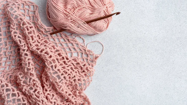 編み物の過程でストリングバッグ ピンクのメッシュバッグ クロチェットホック 残りのヤーン 再利用可能なショッピングバッグ — ストック写真