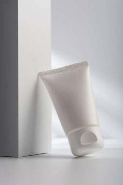 Beyaz zemin üzerinde duran beyaz bir yüz kremi tüpü ya da nemlendirici maket ve kozmetik ürün görüntüleme için