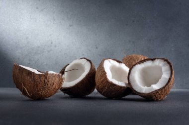 Çatlak hindistan cevizi meyvesi grubu ve dramatik ışıkla birlikte koyu arkaplanda hindistan cevizi.