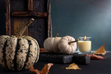 Sonbahar ve Şükran Günü tatilleri için arka planda küçük dekoratif balkabakları ve cam aromalı mum ev dekorasyonu.