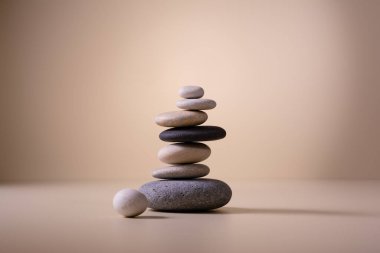 Bej arka planda çakıl taşlarını dengelemek. Rahatla, meditasyon ve zen konsepti.