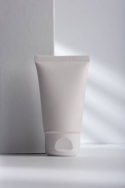 Kozmetik modelleme için açık gri arka planda beyaz yüz kremi tüpü. Sağlıklı kozmetoloji, cilt bakımı ve güzellik tedavisi yaratıcı kavram. 
