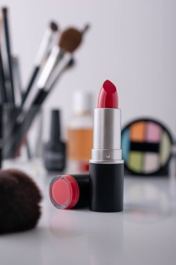 Dekoratif makyaj sehpası ve ön planda kırmızı ruj, seçici odaklanma. Güzellik ürünü ve makyaj konsepti. 
