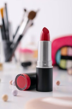 Dekoratif makyaj sehpası ve ön planda kırmızı ruj, seçici odaklanma. Güzellik ürünü ve makyaj konsepti. 