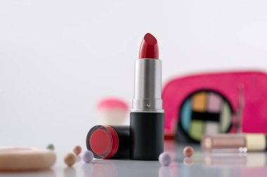 Dekoratif makyaj sehpası ve ön planda kırmızı ruj, seçici odaklanma. Güzellik ürünü ve makyaj konsepti. 