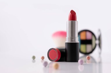 Dekoratif makyaj sehpası ve ön planda kırmızı ruj, seçici odaklanma. Güzellik ürünü ve makyaj konsepti. 