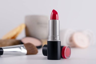 Dekoratif makyaj sehpası ve ön planda kırmızı ruj, seçici odaklanma. Güzellik ürünü ve makyaj konsepti. 