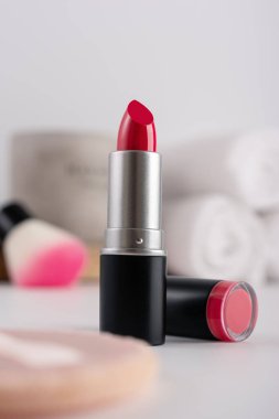 Dekoratif makyaj sehpası ve ön planda kırmızı ruj, seçici odaklanma. Güzellik ürünü ve makyaj konsepti. 