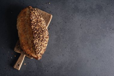 Ev yapımı organik tahtadan yapılmış tahıl ekmeği. Sağlıklı beslenmek için tahıl unundan yapılmış lezzetli kahverengi ekmek.