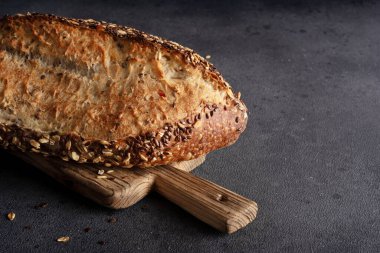 Ev yapımı organik tahtadan yapılmış tahıl ekmeği. Sağlıklı beslenmek için tahıl unundan yapılmış lezzetli kahverengi ekmek.