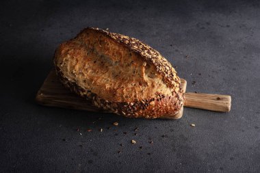 Ev yapımı organik tahtadan yapılmış tahıl ekmeği. Sağlıklı beslenmek için tahıl unundan yapılmış lezzetli kahverengi ekmek.