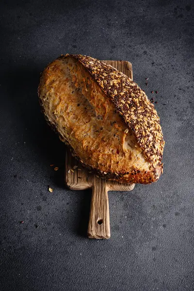 Ev yapımı organik tahtadan yapılmış tahıl ekmeği. Sağlıklı beslenmek için tahıl unundan yapılmış lezzetli kahverengi ekmek.