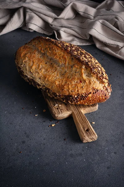 Ev yapımı organik tahtadan yapılmış tahıl ekmeği. Sağlıklı beslenmek için tahıl unundan yapılmış lezzetli kahverengi ekmek.