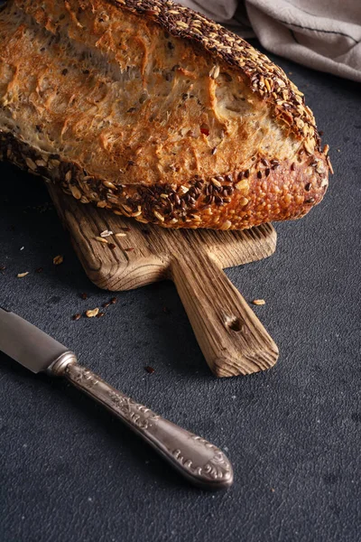 Ev yapımı organik tahtadan yapılmış tahıl ekmeği. Sağlıklı beslenmek için tahıl unundan yapılmış lezzetli kahverengi ekmek.