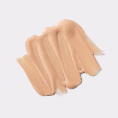 Sıvı fondöten ya da açık gri arka planda BB lekesi. Cilt rengi, krem kumaş örneği..