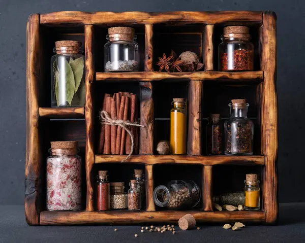 Seasoning (herbs and spices) in small bottles with cork in a wooden box