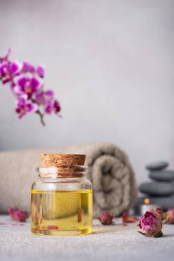 Gerekli yağları, pürüzsüz çakıl taşlarını, sarılmış gri bir havluyu ve canlı mor bir orkideyi barındıran sakin bir spa. Kompozisyon sakinlik ve denge yayar, rahatlık ve rahatlama temaları için mükemmeldir..