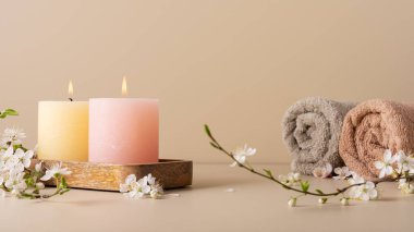 Mumları yakmak, spa odasındaki masaya aroma yaymak. Pastel renkli mumlar ve spa tedavisi için kiraz çiçeği dallarıyla güzel bir kompozisyon.. 