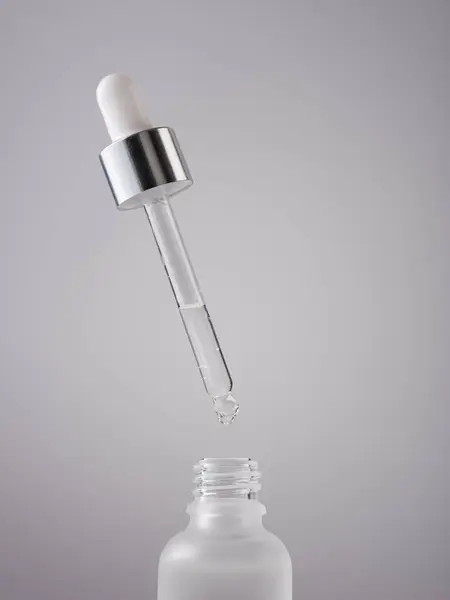 Serumflasche Mit Pipette Auf Grauem Hintergrund Close Milchglasbehälter Für Hautpflege lizenzfreie Stockbilder