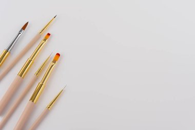 Gri arkaplandaki tırnak sanatsal fırçaları, kopya alanı olan üst görünümü ayarla