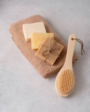 El yapımı sabunlar, havlu ve ahşap masaj fırçası. Vücut bakımı ve sağlık konsepti.