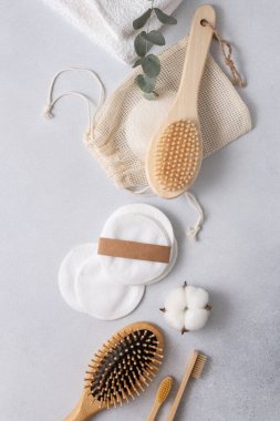 Yeniden kullanılabilir pamuk pedleri, bambu diş fırçaları ve doğal pamuk çiçekleri ve kumaş kesesiyle düzenlenmiş bir fırça içeren çevre dostu cilt bakımı. Minimalist ve sürdürülebilir sıfır atık güzellik ürünleri.