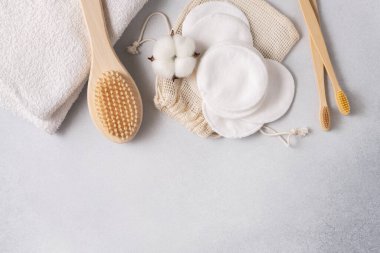 Yeniden kullanılabilir pamuk pedleri, bambu diş fırçaları ve doğal pamuk çiçekleri ve kumaş kesesiyle düzenlenmiş bir fırça içeren çevre dostu cilt bakımı. Minimalist ve sürdürülebilir sıfır atık güzellik ürünleri.