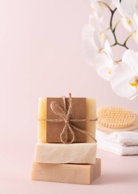 Bambu arka fırçası, el yapımı sabun çubukları ve ahşap tepside duran ve yanında narin bir orkide çiçeği bulunan doğal cilt bakımı ürünleri. Spa, sağlık ve güzellik kavramları için mükemmel..