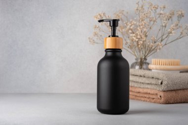 A black dispenser bottle of lotion or shower gel for body care product mock-up. Wellness and selfcare product packaging concept.