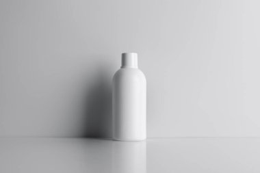 Gri arka planda gölgeleri olan minimalist beyaz kozmetik şişe modeli. Ürün ambalajlama sunumları için ideal, zarafet, sadelik ve modern tasarım güzellik ve cilt bakımında vurgulanıyor.