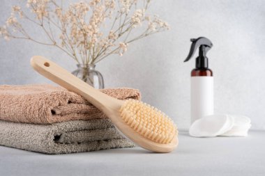 Kişisel bakım için minimalist banyo gereksinimleri, bambu vücut fırçası, yumuşak havlular ve organik cilt ürünleri. Sakin ve doğal ortamlarda çevre bilinci spa ya da sağlık teması için idealdir..