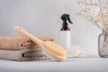 Kişisel bakım için minimalist banyo gereksinimleri, bambu vücut fırçası, yumuşak havlular ve organik cilt ürünleri. Sakin ve doğal ortamlarda çevre bilinci spa ya da sağlık teması için idealdir..