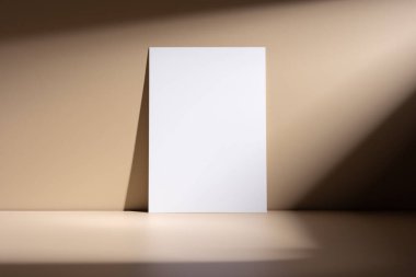 Bej renksiz arka planda gölgeleri olan minimalist boş model poster. Ürün gösterisi, markalaşma ya da sanat gösterisi için mükemmel, basitliği, zarafeti ve modern tasarımı vurguluyor..