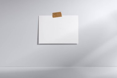 Minimalist beyaz ya da gri arkaplan, boş beyaz bir poster, soyut ve modern bir kompozisyon için zıtlık ve gölge oyunu yaratıyor. Tasarım, sanat veya grafik sunum kavramları için ideal.