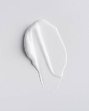 Close-up of white skincare cream smear with smooth texture on a minimalist background. Ideal for beauty, self-care, hydration, and wellness themes, showcasing clean and simple aesthetics.