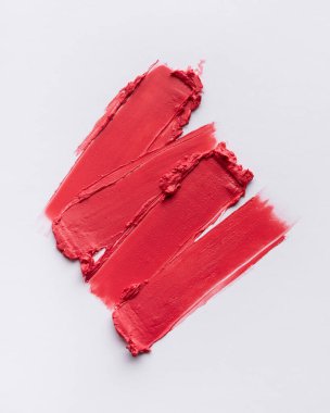 Beyaz arka planda kırmızı ruj lekeli doku. Kozmetik, cilt bakımı ve moda ile ilgili projeler için ideal.