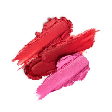 Kırmızı ve pembe tonlarda karışık ruj lekeleri ve parlak bir cilt ve parlak bir kaplama. Güzellik, moda ve makyaj kavramları için canlı ve sanatsal kozmetik örnekleri.