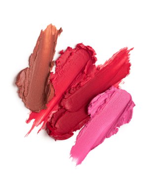 Kırmızı, pembe ve kahverengi tonlarda karışık ruj lekeleri ve parlak bir kaplama. Güzellik, moda ve makyaj kavramları için canlı ve sanatsal kozmetik örnekleri.
