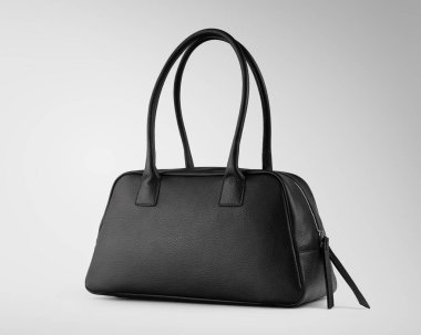 Beyaz arka planda siyah deri bir çanta. Zarif, şık ve modern moda aksesuarları. Minimalist bir tasarımı var. Ticari, lüks ve günlük kullanım için mükemmel..