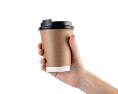 İnsan eli, beyaz arka planda siyah kapaklı kahverengi bir tek kullanımlık kahve fincanını tutuyor. Paket içecek, çevre dostu ambalaj, minimal stil, kafein..