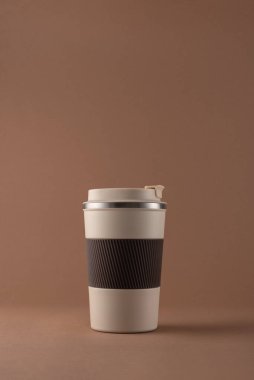 Yeniden kullanılabilir kahve fincanı, doğal gölgeli sıcak bej arka plan modeli. Markalaşma, paketleme, eko tasarım veya reklam için minimalist ürün şablonu. 