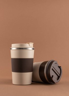 Yeniden kullanılabilir kahve fincanı, doğal gölgeli sıcak bej arka plan modeli. Markalaşma, paketleme, eko tasarım veya reklam için minimalist ürün şablonu. 