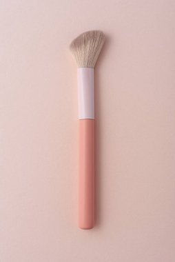 Pastel arka planda düz pembe makyaj fırçası. Kozmetik markalaşma, ürün sunumu, reklam veya güzellik endüstrisi tasarım projeleri için minimalist modelleme şablonu.
