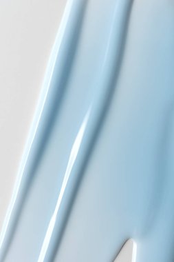 Mavi parlak kozmetik jel dokusu. Çivi sanatı için kremsi, güzellik, markalaşma veya minimal tasarım için parlak yüzey içeren çivi ürünlerinin soyut yakın çekimi.