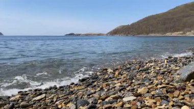 Hafif deniz dalgaları çakıl taşlarının kıyısında köpüğe dönüşür. Suyun geri çekilen sesinde, taşların hafif tıkırtısını duyabilirsiniz. Sakin bir denizi olan terk edilmiş bir körfez. Sakin.