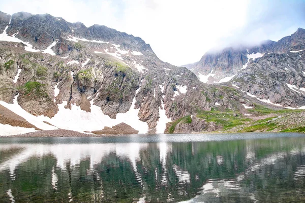 高山湖泊和岩石山 岩石中间的水晶清澈的湖面 湖泊和雪地下的山脉 — 图库照片
