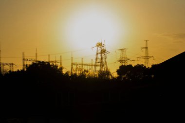 Elektrik santrali gün batımına karşı. Gün batımı ve elektrik kuleleri