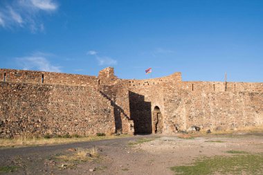 Eski bir kalenin duvarında Ermeni bayrağı var. Kaleye giriş kemeri