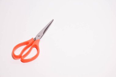 Beyaz arka plandaki kumaşın kesilmesi için makas. en üstteki görünüm